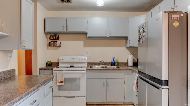 kitchen featuring stainless steel fridge, white electric stove, and sink