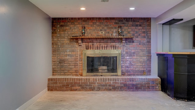 unfurnished living room featuring a brick fireplace and concrete floors