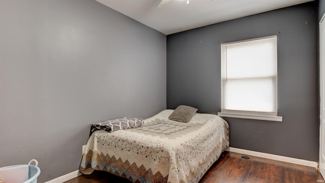 bedroom featuring ceiling fan, dark wood-type flooring, and multiple windows