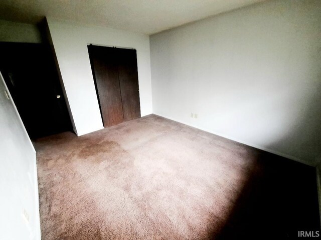 unfurnished bedroom with carpet floors and a closet