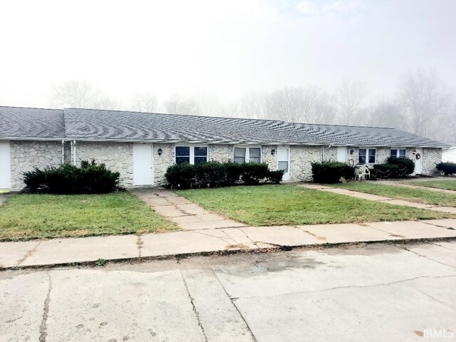 single story home featuring a front lawn