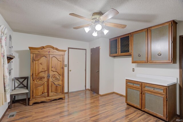 kitchen with ceiling fan, light hardwood / wood-style floors, and a textured ceiling