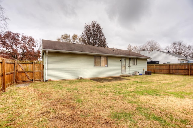 back of property featuring a yard and central AC