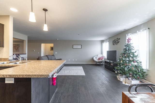 kitchen featuring sink, dark hardwood / wood-style flooring, dark brown cabinetry, and hanging light fixtures