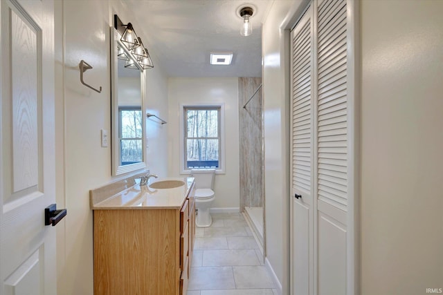 bathroom featuring vanity, tile patterned flooring, toilet, a textured ceiling, and a tile shower