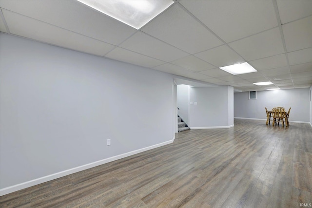 basement featuring wood-type flooring and a drop ceiling