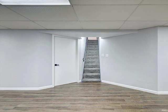 basement with a paneled ceiling and hardwood / wood-style flooring