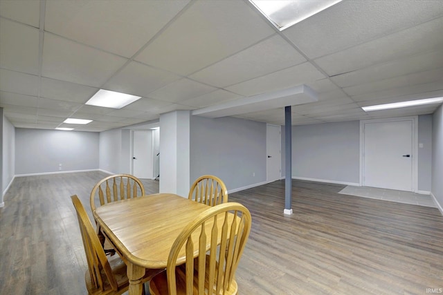 dining area with a paneled ceiling and wood-type flooring