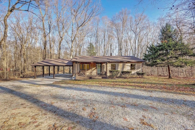 ranch-style home with covered porch and a carport