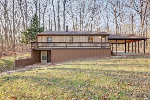 rear view of house featuring a wooden deck and a yard