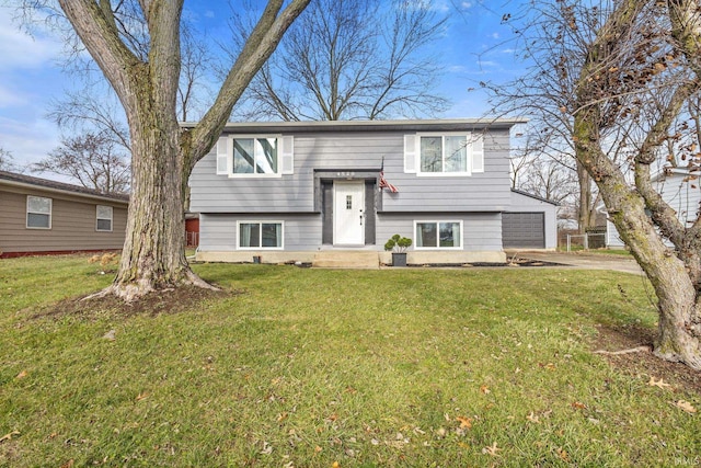 bi-level home featuring a garage and a front lawn