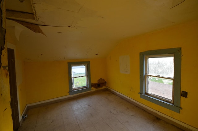 unfurnished room with vaulted ceiling