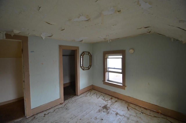 unfurnished bedroom featuring lofted ceiling