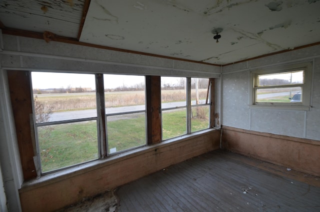 unfurnished sunroom featuring a rural view and plenty of natural light