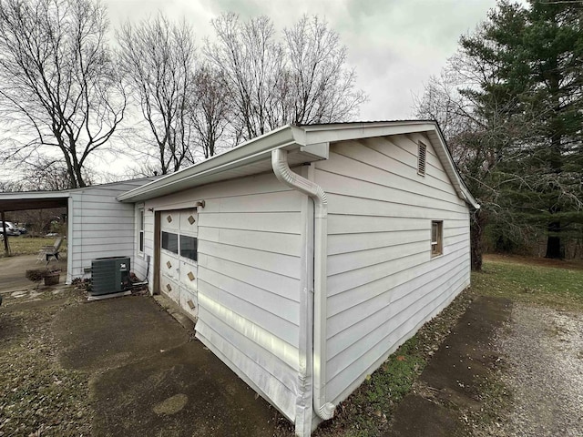 view of side of property featuring a carport and central AC