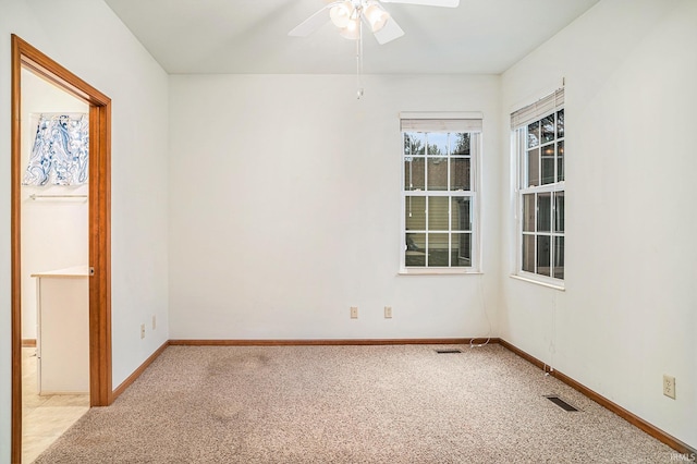 carpeted spare room featuring ceiling fan