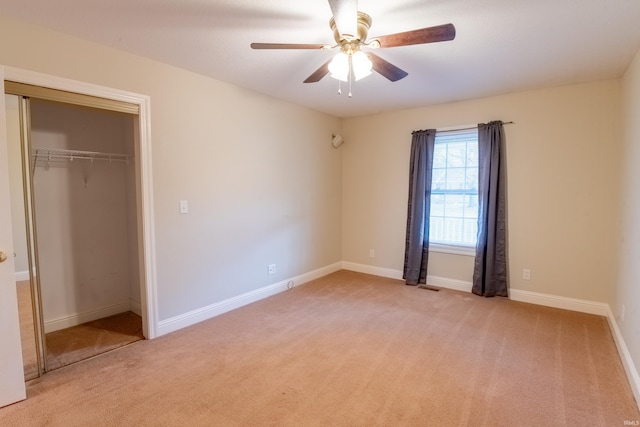 unfurnished bedroom with ceiling fan, a closet, and light carpet