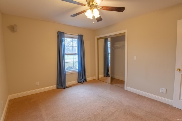 unfurnished bedroom with ceiling fan, light carpet, and a closet