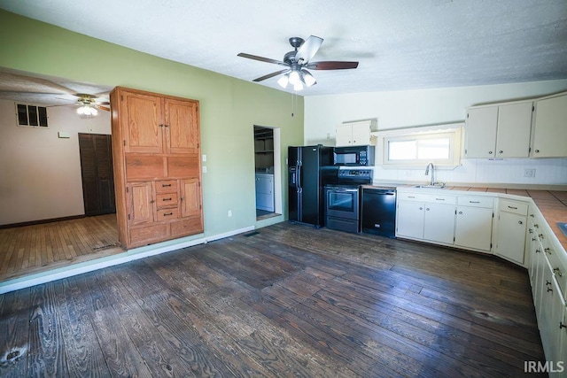 kitchen featuring black appliances, dark hardwood / wood-style flooring, white cabinets, and vaulted ceiling