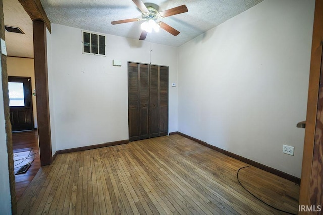 unfurnished room featuring ceiling fan, wood-type flooring, and a textured ceiling