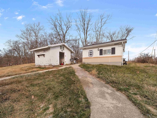 view of front of property featuring an outdoor structure and a front yard