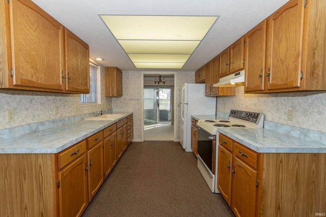 kitchen with dark carpet, white appliances, sink, and a chandelier