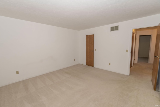 carpeted spare room with a textured ceiling