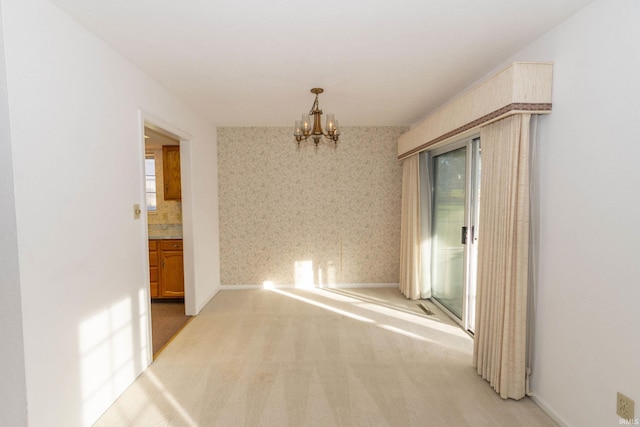 unfurnished room with light carpet and a chandelier