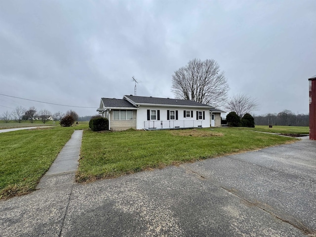 single story home with a front lawn and covered porch