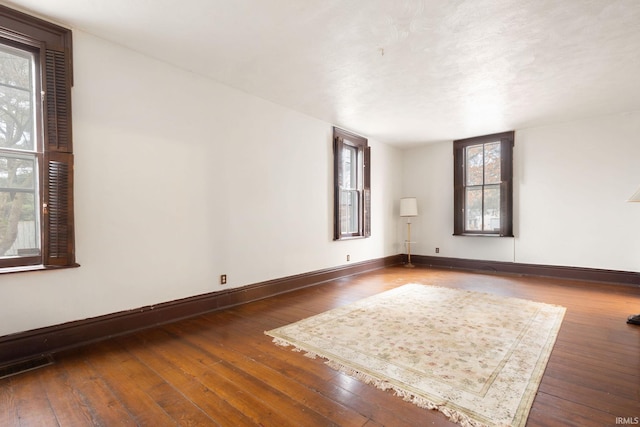 unfurnished room with dark wood-type flooring