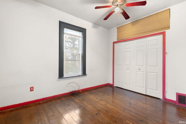 unfurnished bedroom featuring a closet, dark hardwood / wood-style floors, and ceiling fan