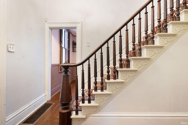 staircase with hardwood / wood-style floors