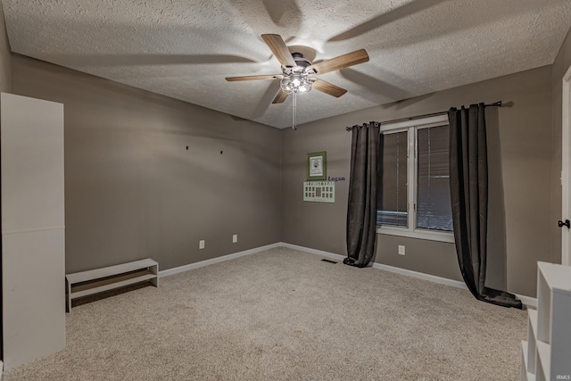 carpeted spare room featuring ceiling fan and a textured ceiling