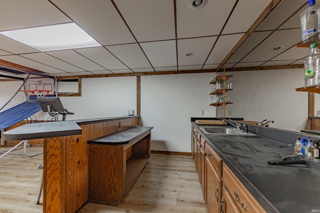 kitchen featuring a drop ceiling, sink, and light hardwood / wood-style flooring