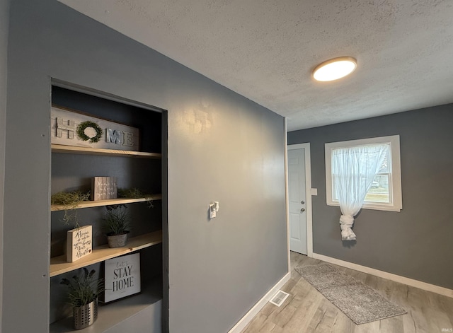 interior space featuring a textured ceiling and light hardwood / wood-style flooring