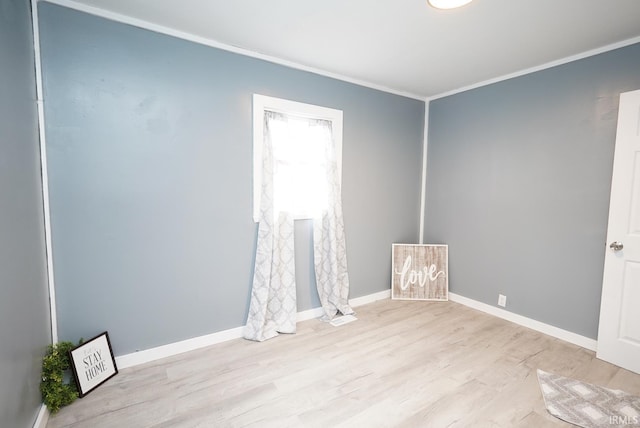 empty room with light hardwood / wood-style floors and ornamental molding