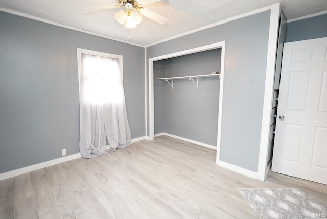 unfurnished bedroom featuring ornamental molding, a textured ceiling, ceiling fan, light hardwood / wood-style floors, and a closet