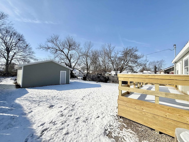 yard layered in snow featuring an outdoor structure and a deck