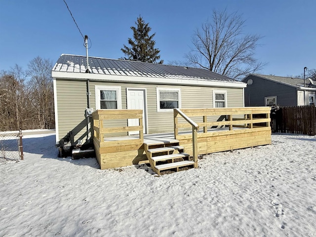 snow covered property with a deck