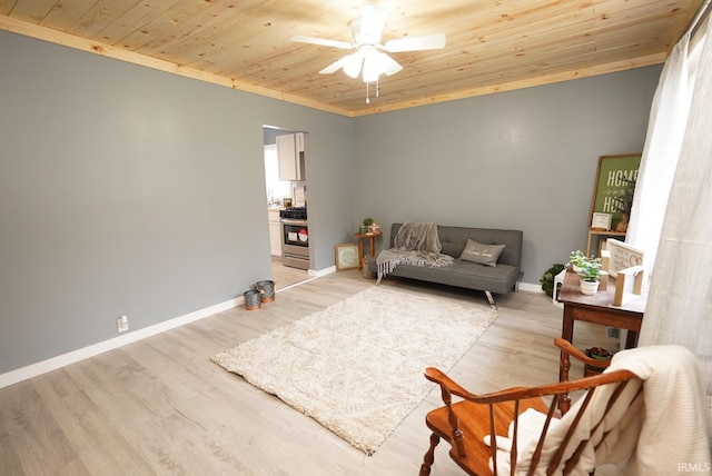 living room with ceiling fan, light hardwood / wood-style floors, and wood ceiling