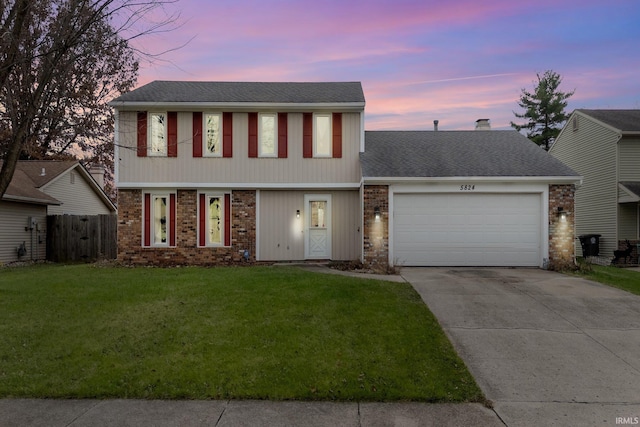 view of front of house featuring a yard and a garage