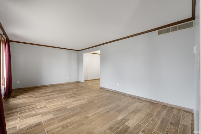 empty room featuring crown molding and light hardwood / wood-style flooring