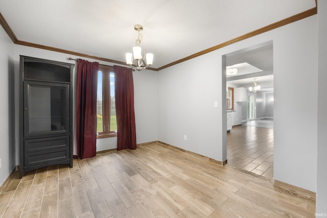 interior space with crown molding, a chandelier, and light wood-type flooring