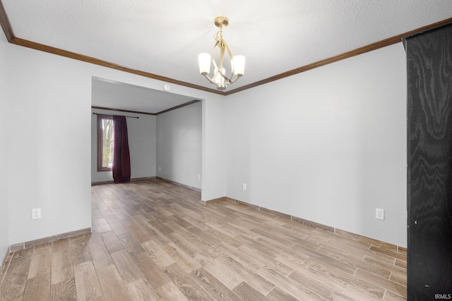 spare room featuring crown molding, a chandelier, a textured ceiling, and light wood-type flooring