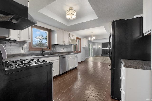 kitchen featuring dark hardwood / wood-style floors, white cabinetry, a tray ceiling, and black appliances