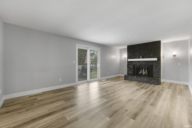 unfurnished living room featuring a textured ceiling, a fireplace, and light hardwood / wood-style flooring