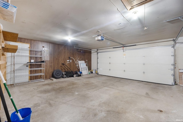 garage featuring a garage door opener and wood walls