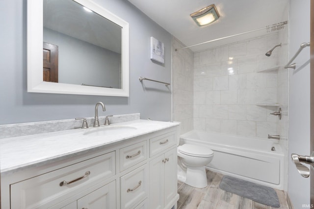 full bathroom featuring toilet, vanity, hardwood / wood-style flooring, and tiled shower / bath combo