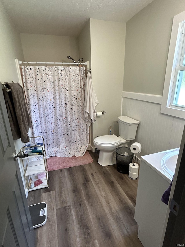 bathroom featuring hardwood / wood-style floors, vanity, curtained shower, and toilet