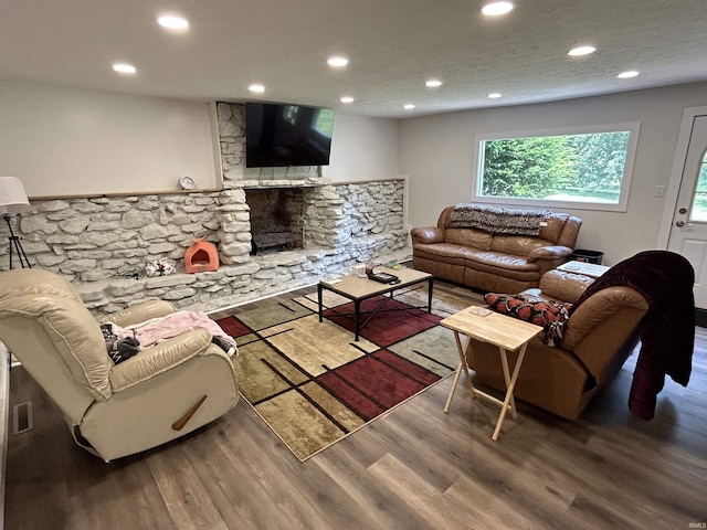 living room with a fireplace, hardwood / wood-style floors, and a textured ceiling